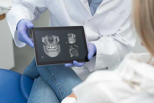 Dentist Showing Teeth X Ray On Tablet Screen