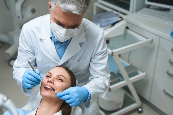 Male Dentist Is Examining Woman Stock Photo